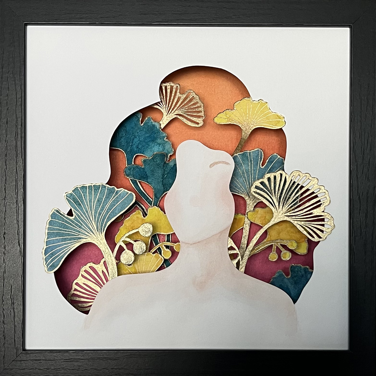 A cut out of a lady with gingko biloba leaves sprouting from her head in greens, golds and oranges. Artwork created by Jewel Starz by Juliana Jones.